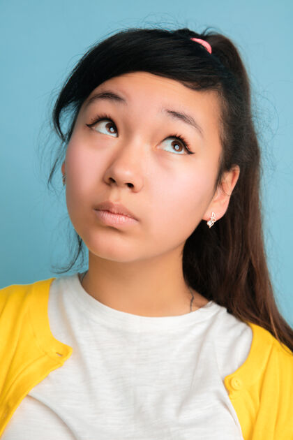 表情亚洲少年的特写肖像被隔离在蓝色的空间里美丽的深褐色长发女模特金融亚洲视频日志