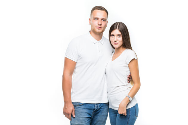 肖像美丽的微笑的年轻夫妇隔离在白色的背景情人站休闲