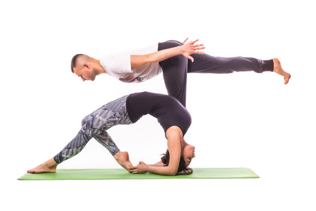 运动情侣在白色工作室练习acro瑜伽acro瑜伽概念双人瑜伽瑜伽柔韧性课程锻炼肢端瑜伽健身女性