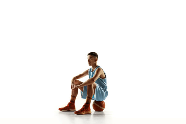 运动一个年轻的篮球运动员与一个球在空白处孤立的全长肖像运动员动作娱乐