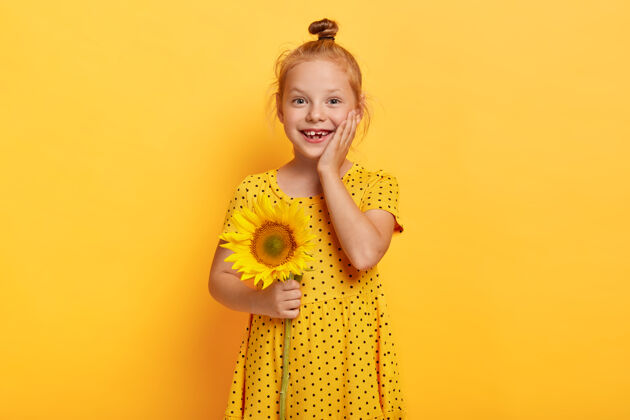 人美丽的小红发女孩与黄裙向日葵合影时尚童年欢乐