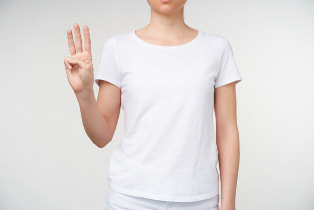手势一张年轻女性手上裸体修指甲的不规则照片 显示了三个手指 意思是字母w 穿着休闲服站在白色背景上女士符号休闲