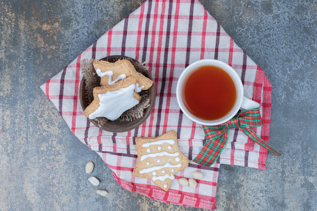 节日星型姜饼饼干和一杯茶在桌布上高品质的照片小吃桌布糕点