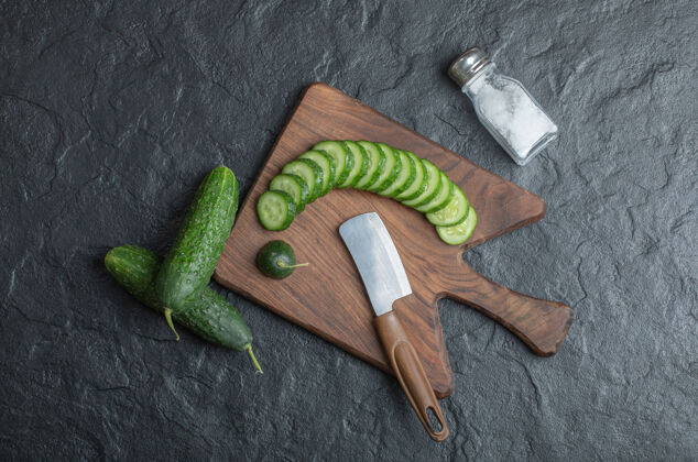 有机在木板上用盐和刀切成片或整片黄瓜高质量的照片新鲜植物厨房