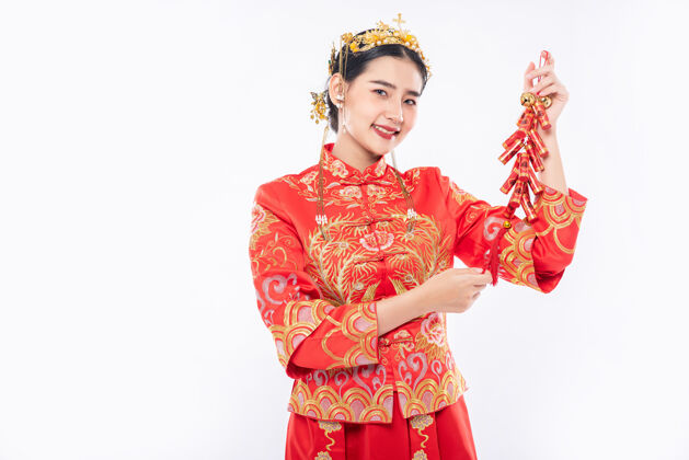 中国文化女人穿旗袍套装笑着从老板那里得到鞭炮在中国新年欢呼旗袍文化