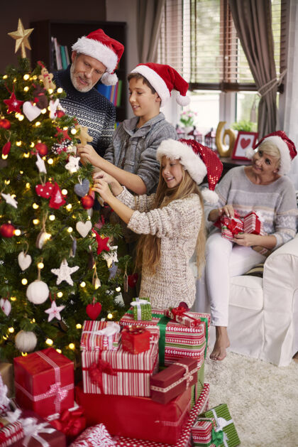 舒适全家人都在装饰圣诞树帮助惊喜圣诞装饰品