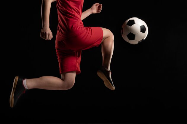 足球制服近景女子用膝盖踢球跳跃踢女子