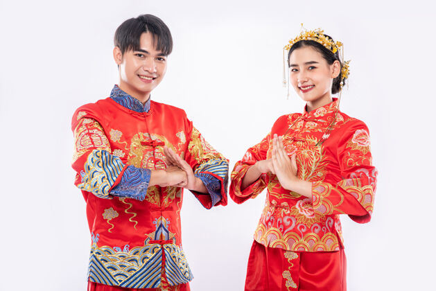 中国新年男人和女人穿旗袍来表达他们的敬意在白色背景上孤立成熟荣誉传统服装