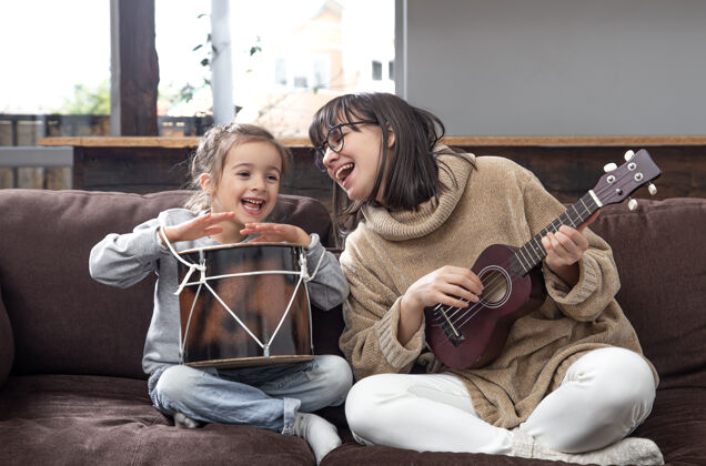 快乐妈妈和女儿在家里玩上乐器课孩子的成长和家庭价值观孩子的友谊和家庭观念孩子游戏娱乐