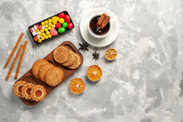 顶部顶视图不同的饼干与糖果和一杯茶的白色背景饼干饼干糖烤蛋糕甜馅饼饼干饼干蛋糕