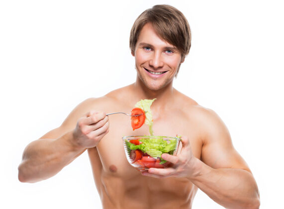 素食者年轻快乐的肌肉男在白墙上吃沙拉蔬菜帅哥沙拉