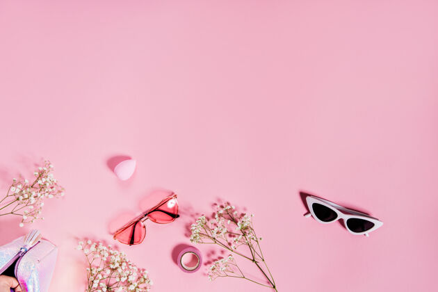 制作可爱的两副太阳镜在粉色墙上的照片 上面有花美丽笔记本明星