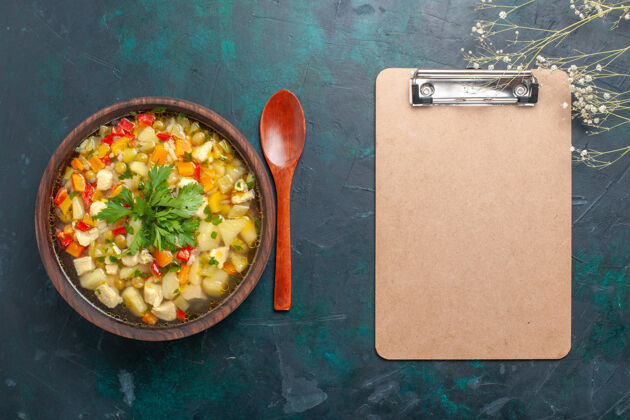 不同的俯瞰美味的蔬菜汤与不同的配料和记事本上黑暗的书桌汤蔬菜酱食品热菜一餐视图肉生的