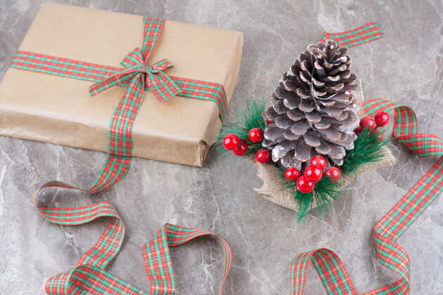 圣诞盒子巨大的节日圣诞松果 大理石背景上有礼物和蝴蝶结盒子松果圣诞蝴蝶结
