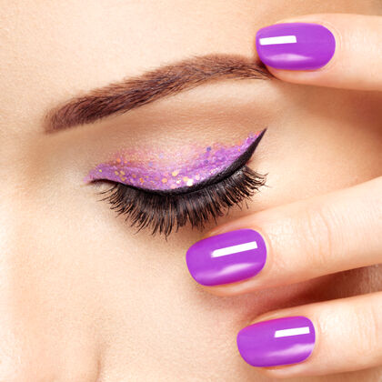 指甲紫罗兰色眼妆的女人的眼睛宏观风格的形象睫毛发亮长