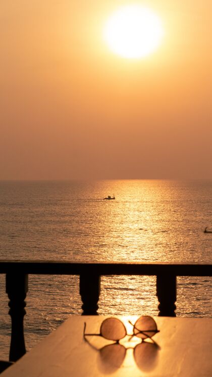 太阳镜日落时 一副太阳镜放在海边的桌子上沙滩海洋海岸线