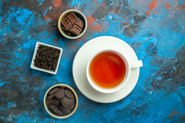 视图俯视一杯茶巧克力在蓝红色的小碗表面茶碟茶汤碗