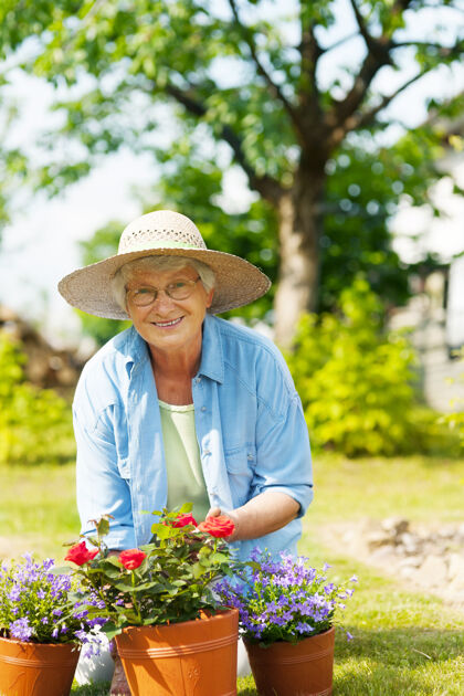 女人花园里拿着花的老妇人微笑一个人玫瑰