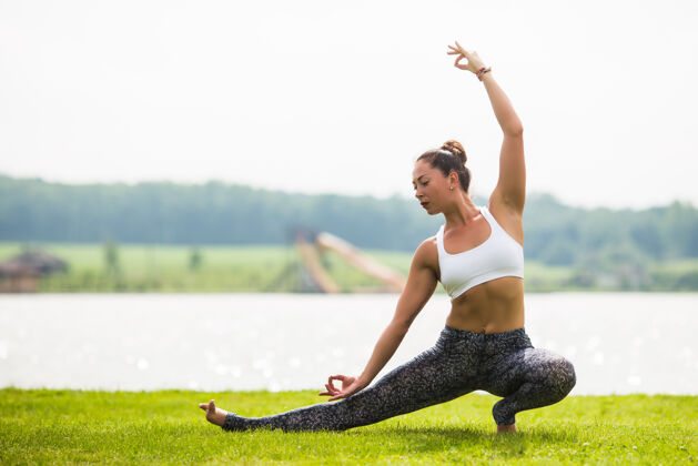运动年轻女子早上在阳光下的公园里做瑜伽姿势减肥阳光女人