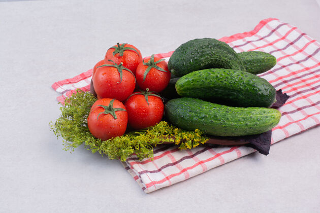 成熟新鲜的黄瓜 西红柿和绿色的桌布罗勒有机有光泽