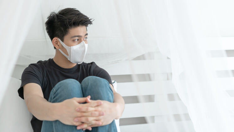 14天亚洲男子戴口罩以防在检疫室因冠状病毒冠状病毒-19而感到头痛和咳嗽病毒传播冠状病毒防护