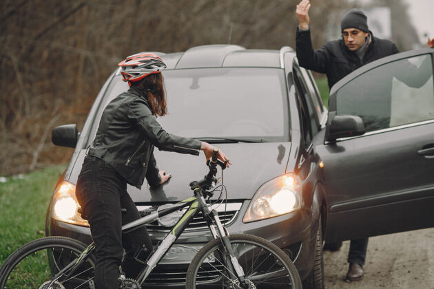 骑行那个女人撞到了车上那个戴头盔的女孩人们为事故争吵起来女性骑自行车撞击