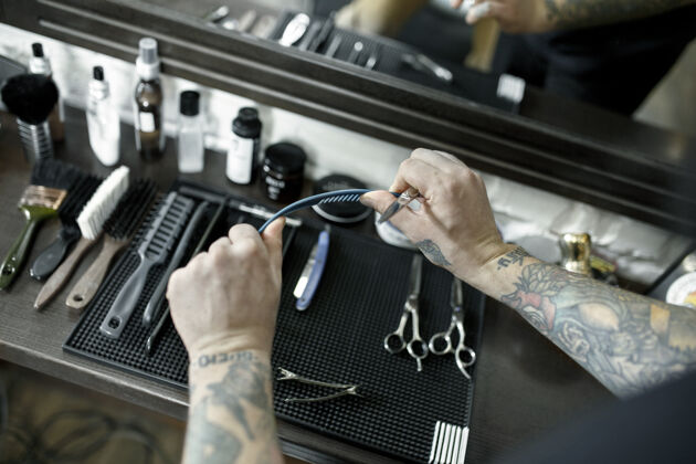 理发在理发店剪胡子的男人的手和工具客户梳子手