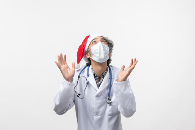 大流行正面图：男医生带着无菌口罩在白色办公桌上共济病毒大流行新年医生医院制服