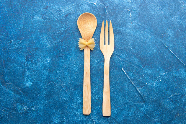 金属顶视图木制叉子勺farfalle上勺蓝色桌子上的自由空间餐厅餐具套装