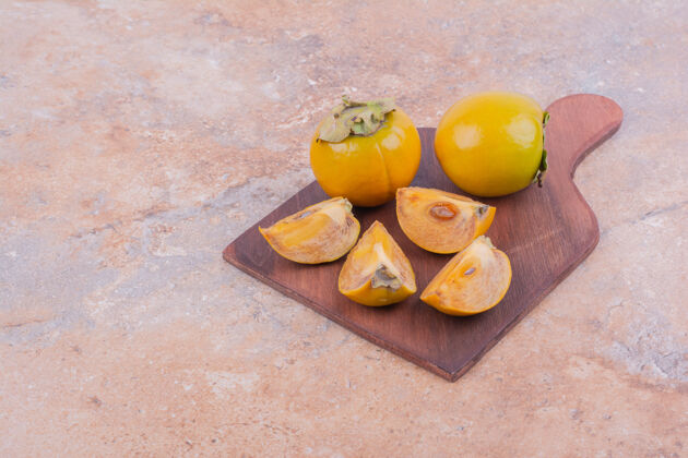 食物整个李子和切成片的枣子放在木板上热带生物健康