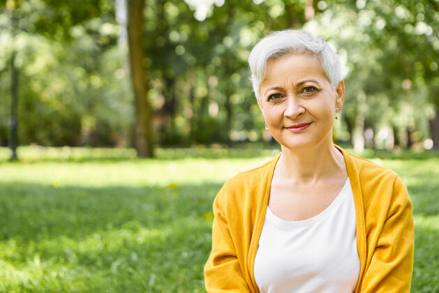 老年人夏季 成熟的人 年龄和休闲的概念户外拍摄的时尚白种女人退休与灰色短发穿着黄色开衫放松在野外自然 微笑成熟公园退休者