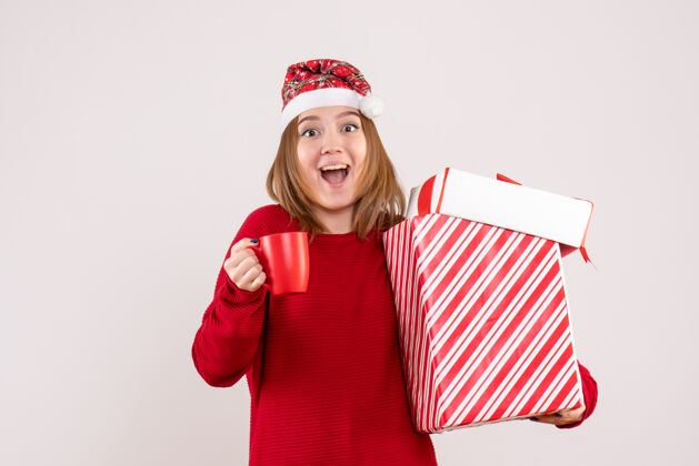 礼物带着礼物和一杯茶前视年轻女性圣诞节茶杯子