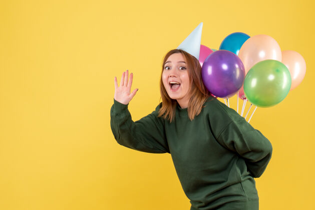 颜色正面图年轻女性藏着五颜六色的气球年轻女性女人人