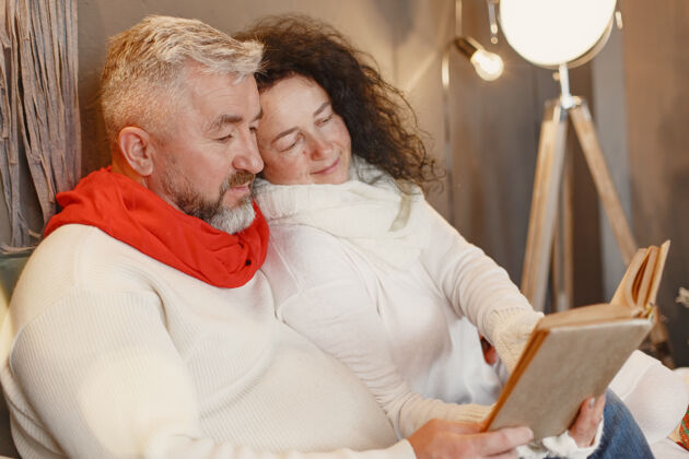 婚姻年龄和人的概念家里的老年夫妇穿着白色针织毛衣的女人庆祝黑发成熟