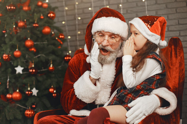 惊喜圣诞节 孩子和礼物圣诞老人给孩子带来礼物快乐的小女孩拥抱圣诞老人盒子圣诞庆祝