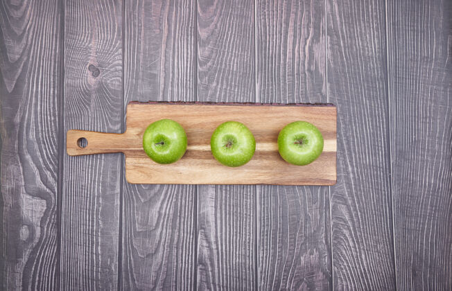 绿色木板上青苹果的俯视图木制甜点新鲜