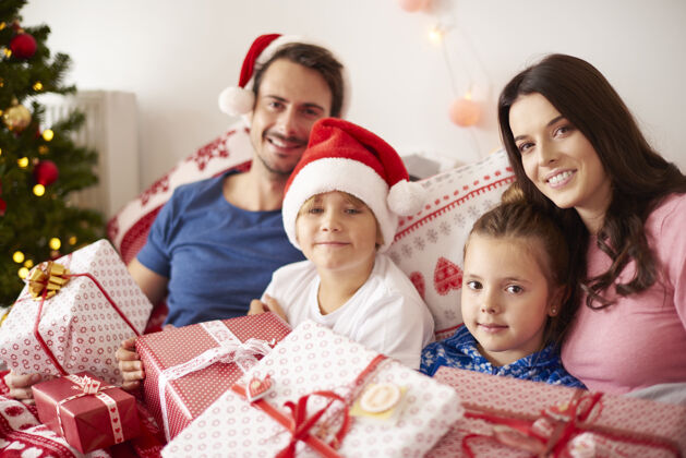 装饰一家人在床上度过圣诞节的早晨结合礼物孩子们