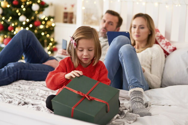 实用儿童打开礼物和家长与数字平板电脑舒适室内家庭