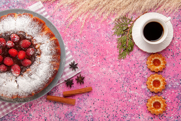 背景俯视美味草莓蛋糕糖粉饼干和一杯茶的粉红色背景蛋糕甜甜饼干饼干茶马克杯茶碟顶部