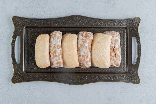 烘焙食品饼干包装在大理石背景上华丽的托盘上美味美味饼干