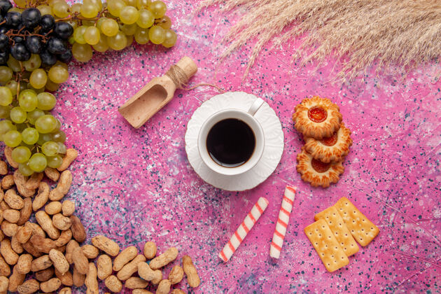 设备顶视图一杯茶配饼干饼干花生和新鲜葡萄桌上粉红色饼干水果坚果色酥脆坚果茶桌子