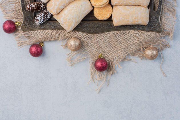 甜点一捆各式各样的饼干放在一个华丽的托盘上 旁边是大理石表面的圣诞饰品美味曲奇填充