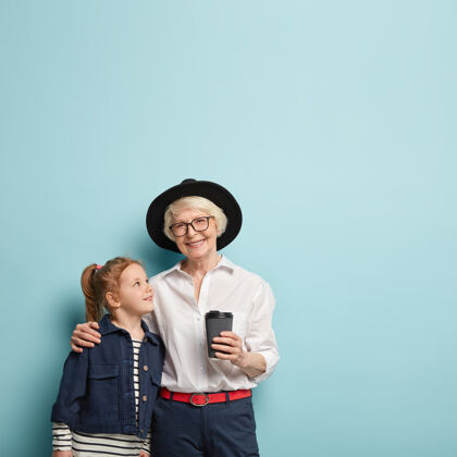 垂直高兴的老太太抱着她的小孙女 告诉一些建议 穿上时髦的衣服高兴老人衰老