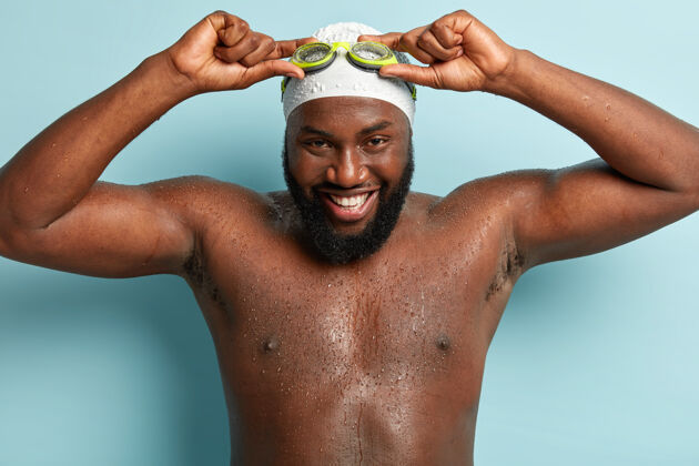 男性快乐的黑皮肤男人 浓密的鬃毛 黑皮肤 赤裸的身体 手戴着护目镜游泳运动员积极胡茬