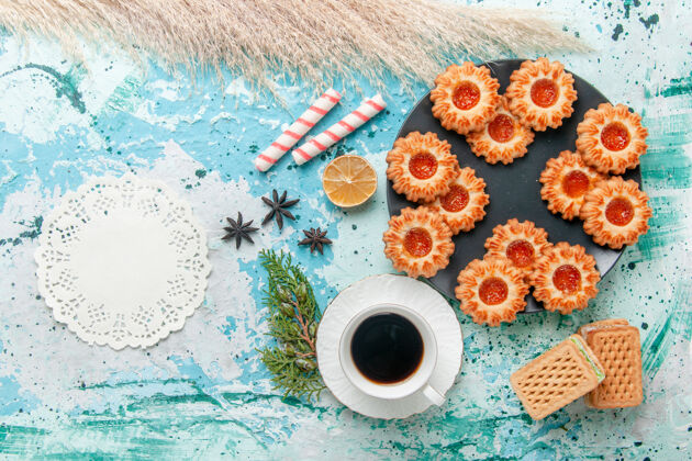 颜色俯瞰美味的小饼干与一杯咖啡和华夫饼上的蓝色办公桌饼干饼干甜甜的糖色茶茶饼干顶部