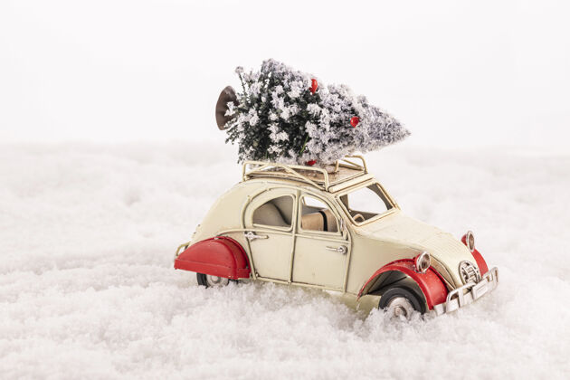 礼物特写一个小的老式玩具车与圣诞树在其屋顶上的人造雪问候季节圣诞节