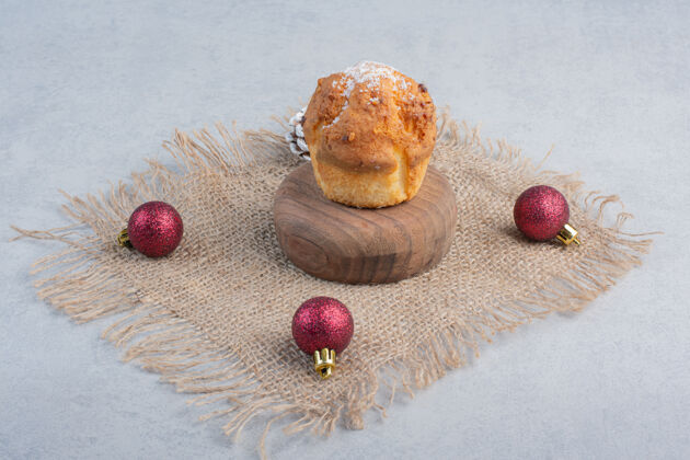 糖果在大理石表面的一块布上放一个纸杯蛋糕和圣诞装饰品纸杯蛋糕松木装饰