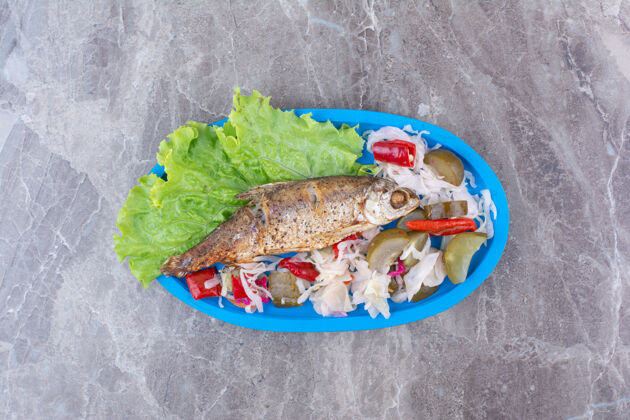 盘子青鱼和腌菜放在蓝色盘子里美味海鲜腌制