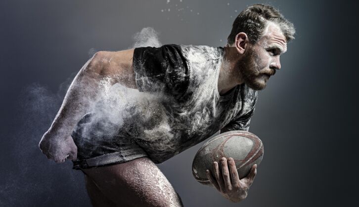 男运动男橄榄球运动员手持灰尘球的侧视图球联盟锦标赛