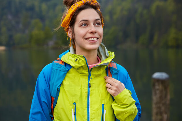 风景梦幻积极的女旅行者有积极的娱乐活动 在绿色的森林和湖泊上摆姿势 穿着休闲服水探险家夹克